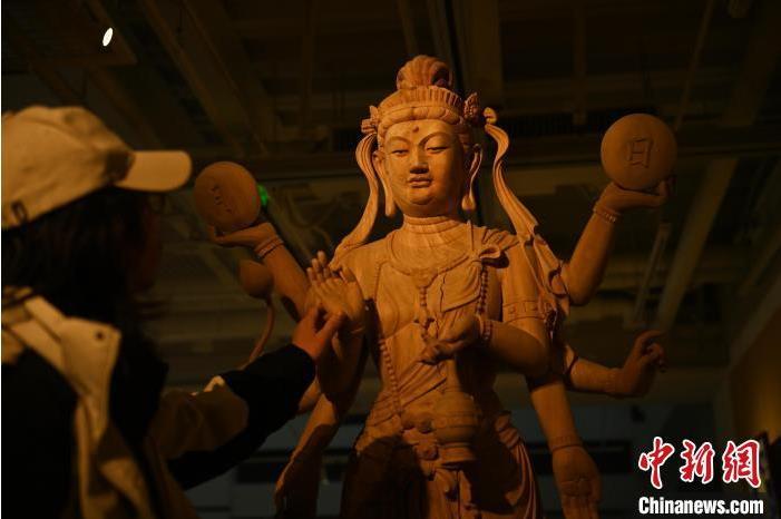圖為季茂杰觀察自己創作的敦煌木雕。李亞龍 攝</p>
<p>
