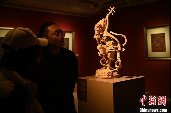 圖為季茂杰向參觀者介紹自己創作敦煌木雕的過程。李亞龍 攝</p>
<p>