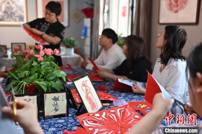 6月6日,在甘肅敦煌青年夜校課程中,青年學(xué)員學(xué)習(xí)敦煌非遺剪紙課程。李亞龍 攝