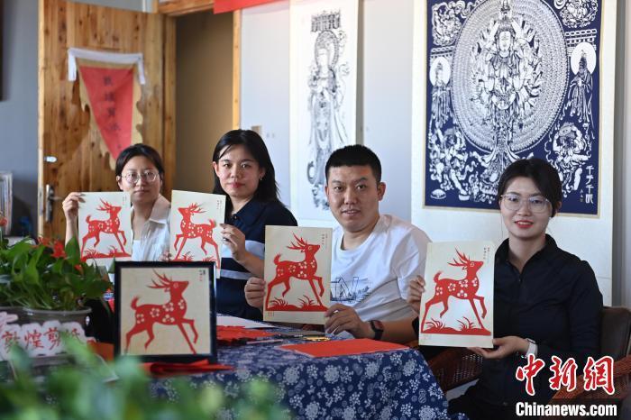 6月6日,在甘肅敦煌青年夜校課程中,青年學(xué)員展示學(xué)習(xí)敦煌非遺剪紙的成果。李亞龍 攝