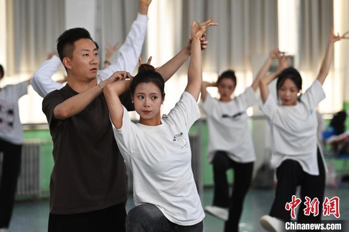 6月6日,在甘肅敦煌青年夜校課程中,青年學(xué)員學(xué)習(xí)敦煌舞課程。李亞龍 攝